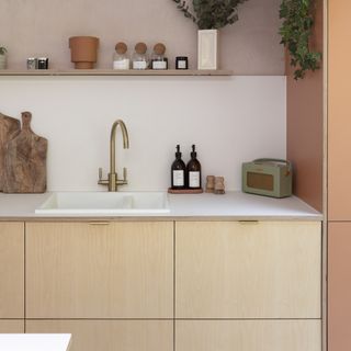 Plywood kitchen with white worktop and brass tap