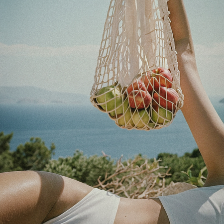 Sustainable living: A woman holding a woven bag of fruit