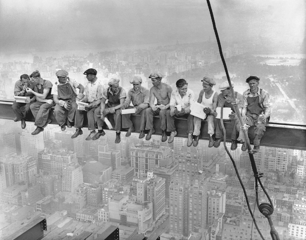 A black and white image of 11 workers sitting on an iron girder high above New York, during the building of the Rockefeller Center