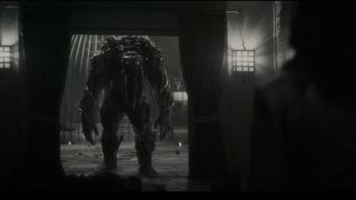 Man-Thing stands in a doorway looking at Elsa Bloodstone in Marvel's Werewolf by Night