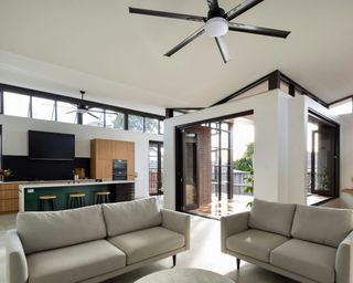 a cream and black living room with pops of light brown wooden furniture