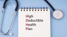 Stethoscope and notepad reading "high deductive health plan"