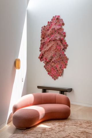 pink woollen artwork hanging above pink sofa in Verso design showroom