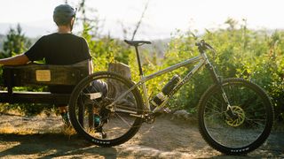 Rider sitting on a bench with the Transition TransAM hardtail MTB