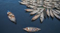 Boatmen ride their boats while other boats are anchored in the Buriganga river during the Eid al-Fitr holiday in Dhaka, Bangladesh