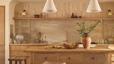 A Tuscan-inspired kitchen with a marble backsplash and a wooden freestanding island