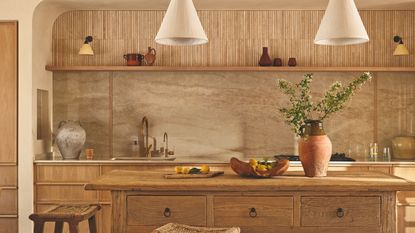 A Tuscan-inspired kitchen with a marble backsplash and a wooden freestanding island