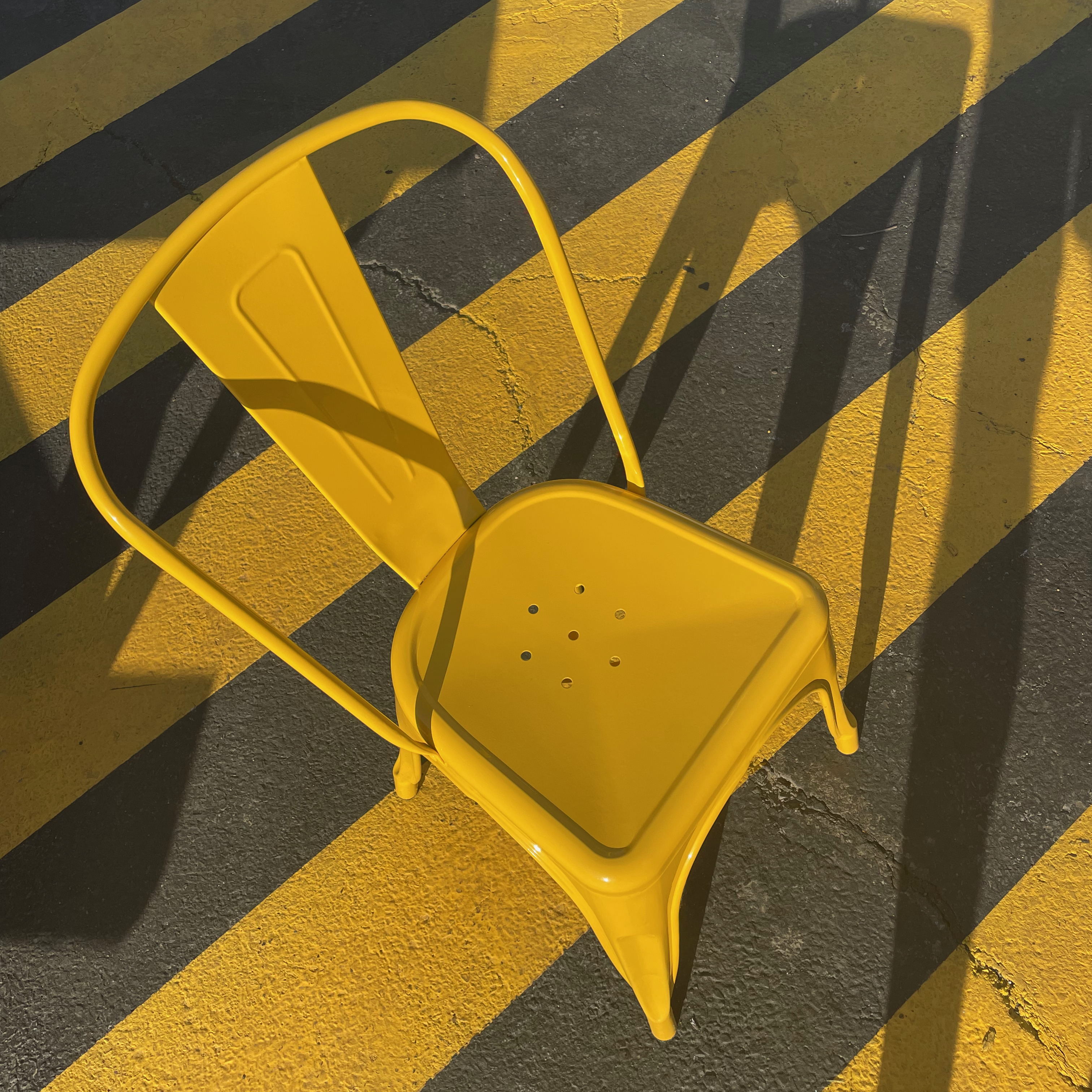 A yellow chair on a yellow-striped path