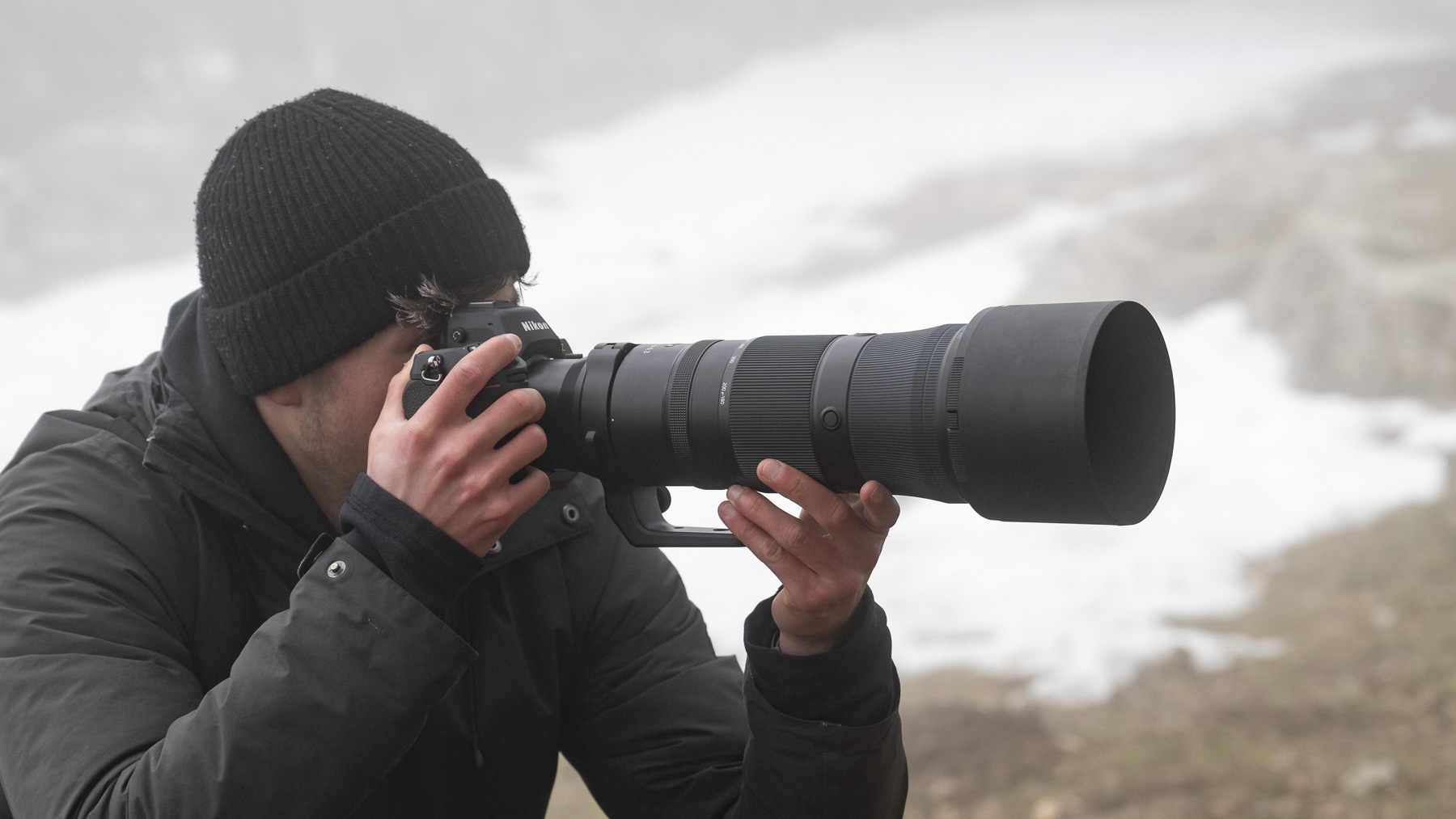 Photographer with the Nikkor Z 180-600mm lens in the hand outdoors wintry location