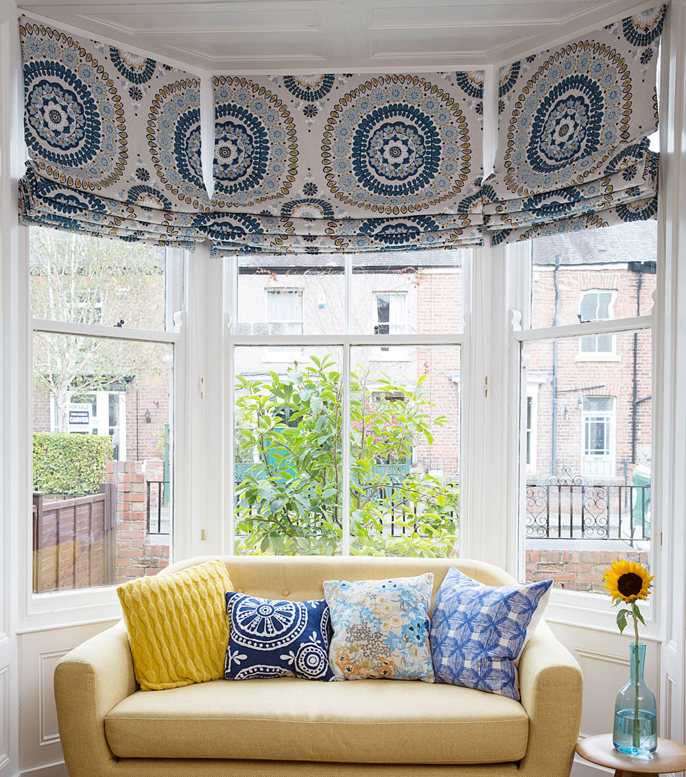 living room with white wall and pillows on couch with sunflower