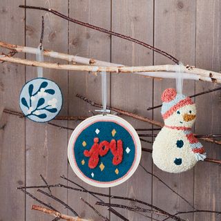 hand made Christmas decorations including a snowman hanging from branches