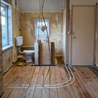 Exposed floorboards and outline of new bathroom