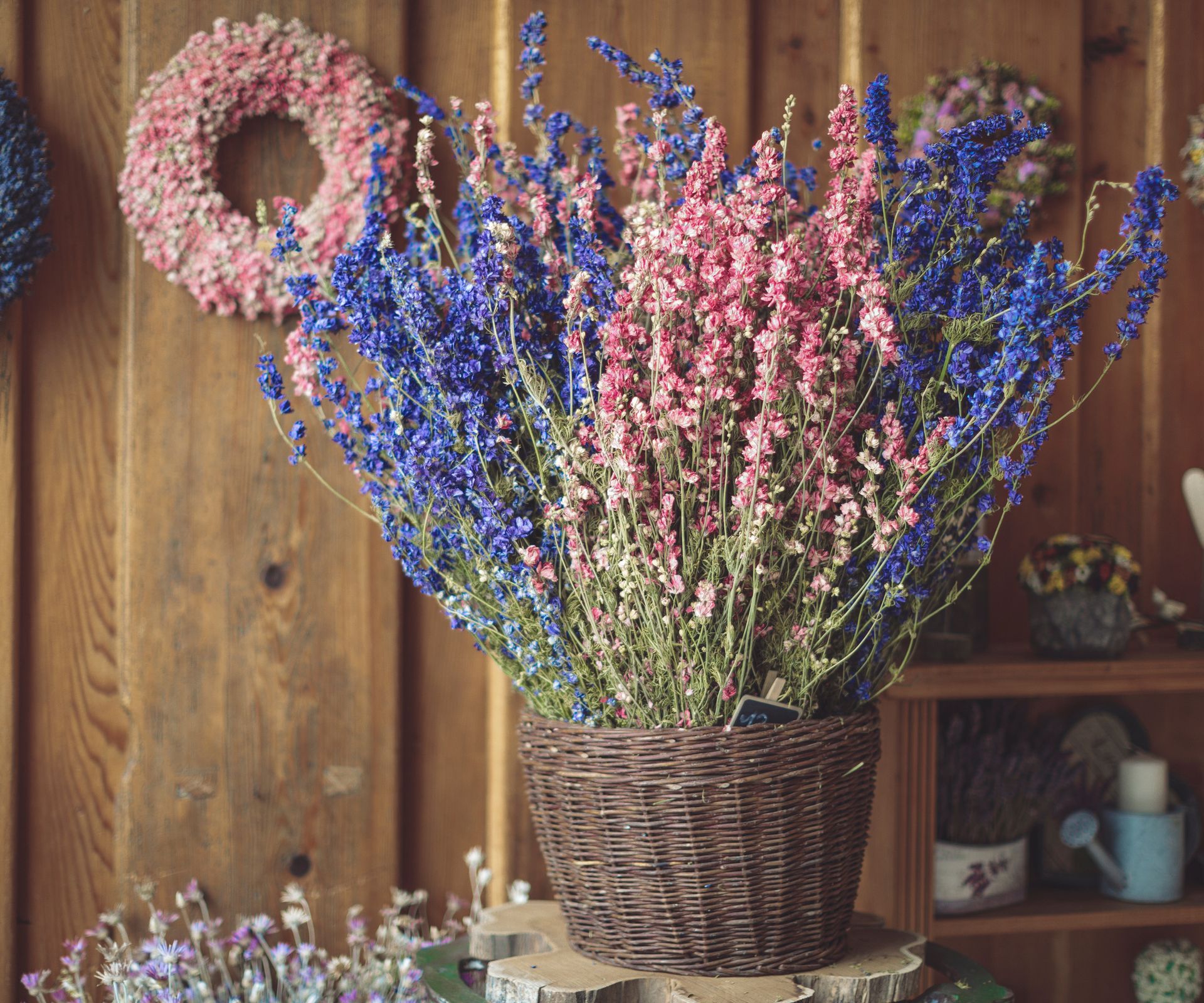 pink and blue dried Larkspur flowers in a basket