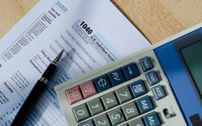 picture of tax forms, a pen, and a calculator