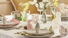 anthropologie easter collection 2025 styled brunch table with spring flowers, eggs in egg cups and bunny rabbit decorations