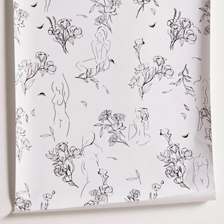 A black and white peel and stick wallpaper with drawings of female figures and florals