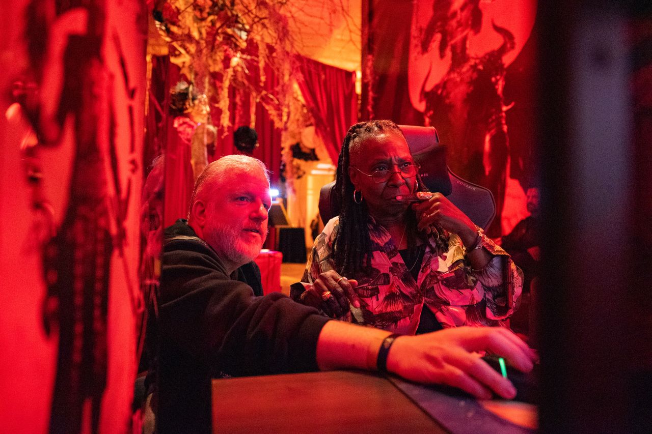 Diablo general manager Rod Fergusson shows Whoopi Goldberg something on an unseen computer monitor.