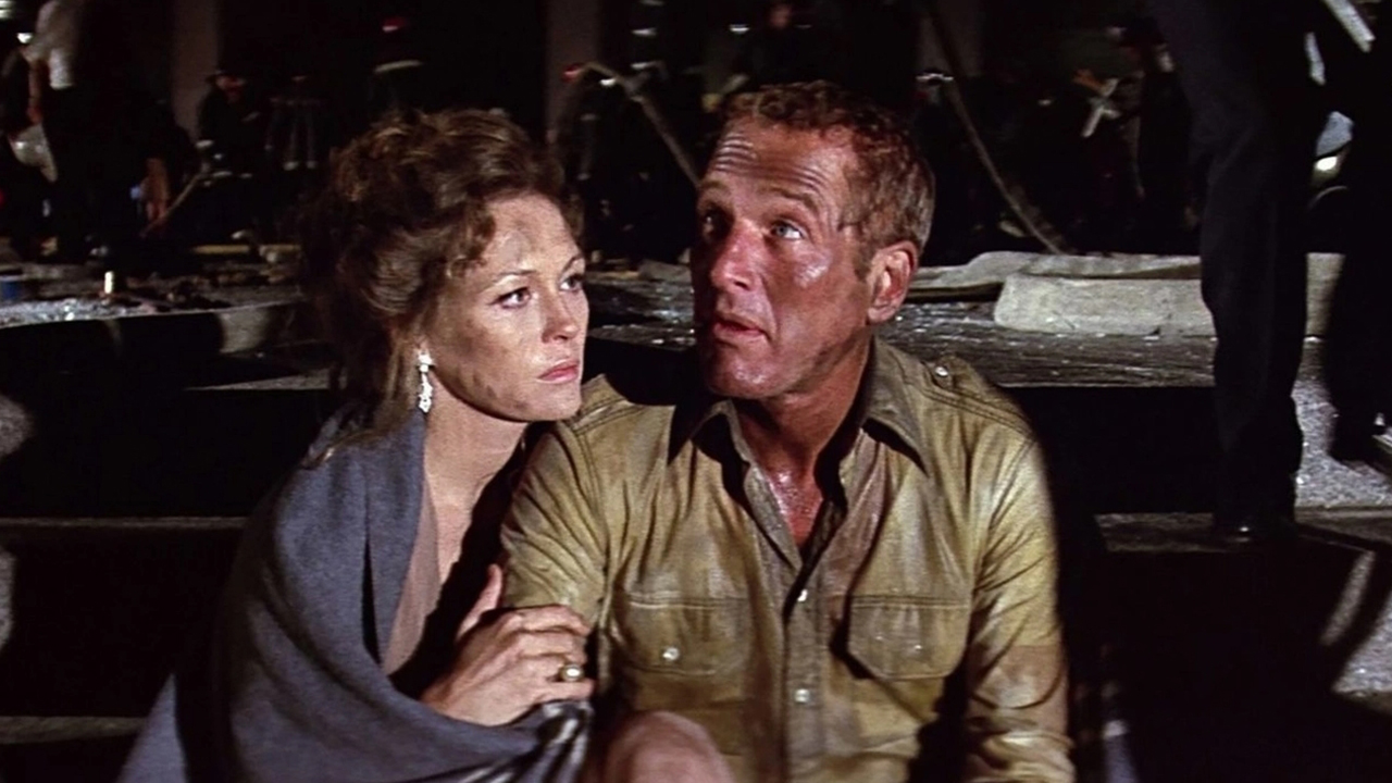 A woman sits next to and hugs a man in a still from the movie 