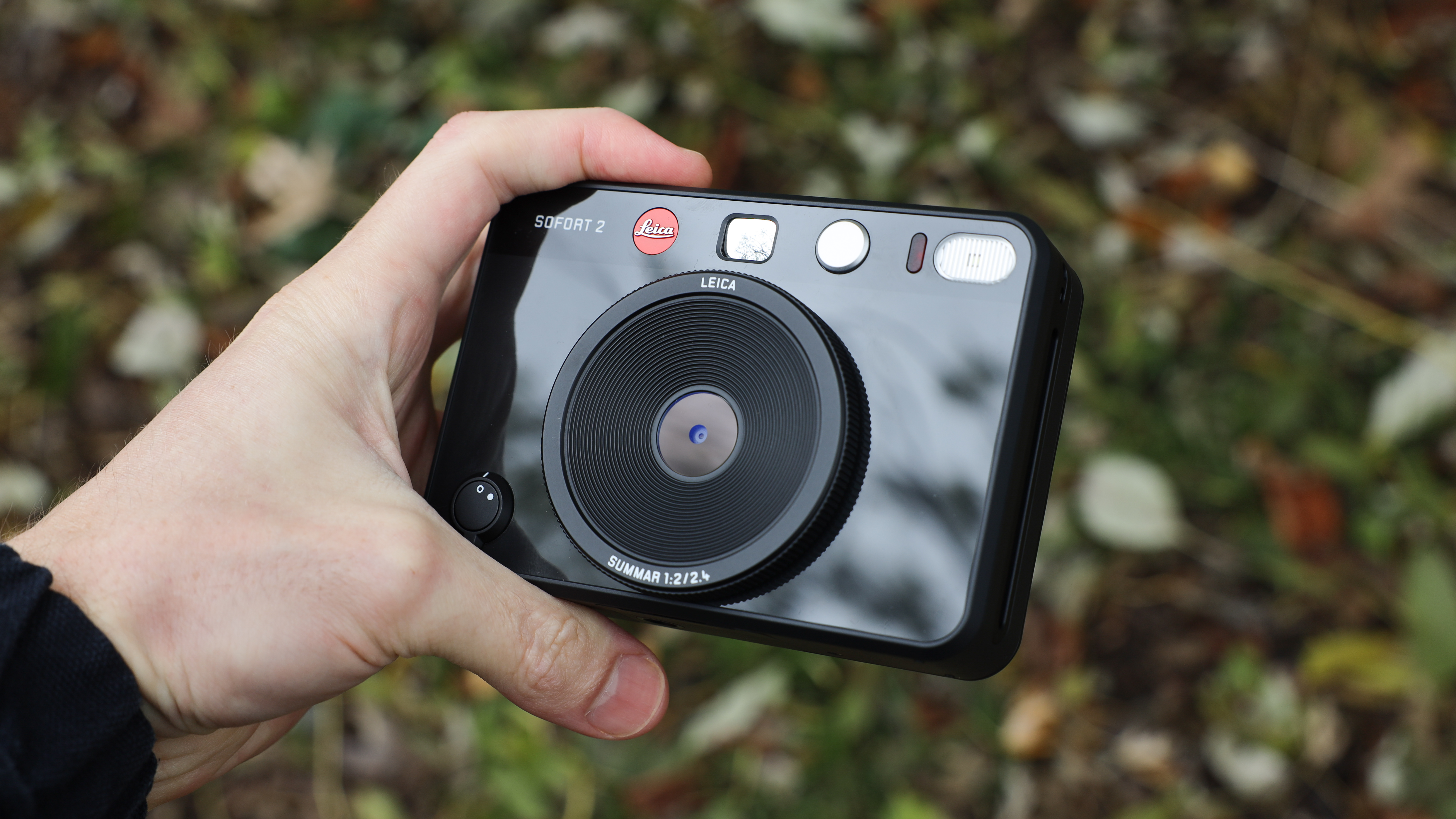 Leica Sofort 2 hybrid camera held in a hand