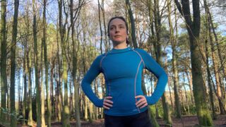 Julia Clarke wearing a blue base layer in the forest