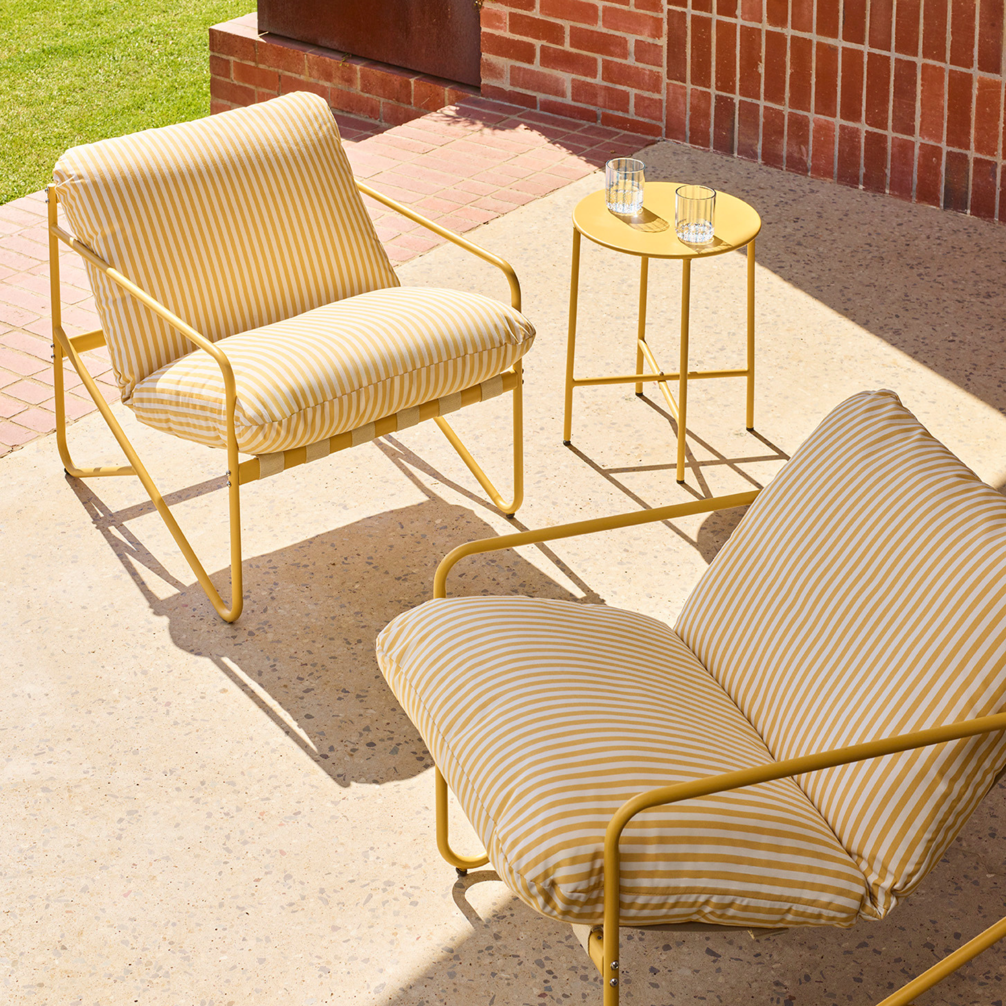 Yellow Tuscany birstro set positoned on a sunny patio.