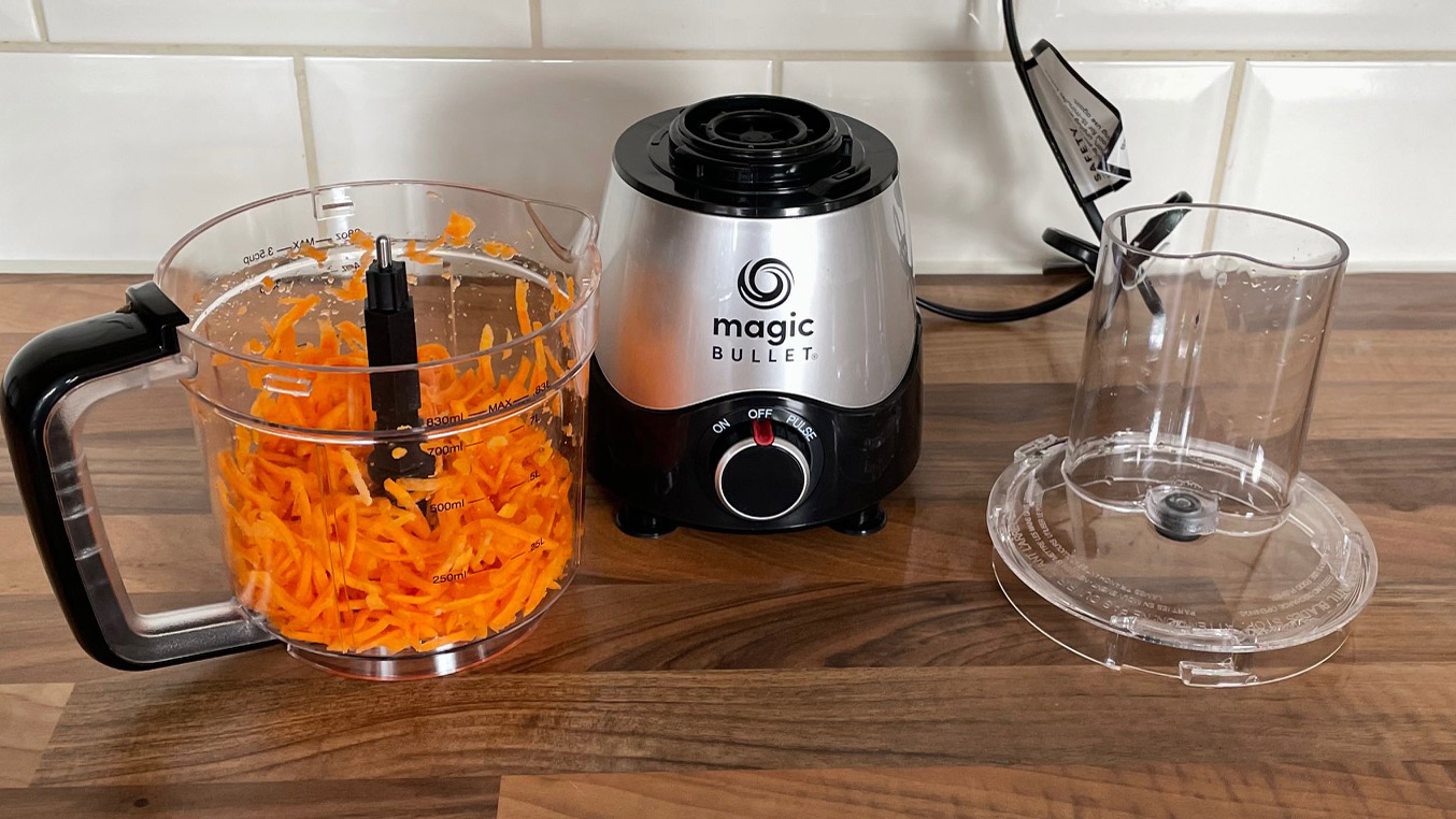 Nutribullet Magic Bullet Kitchen Express on a kitchen countertop with grated carrot in the food processor bowl having just been prepared