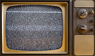 A vintage television set with white static on the screen.