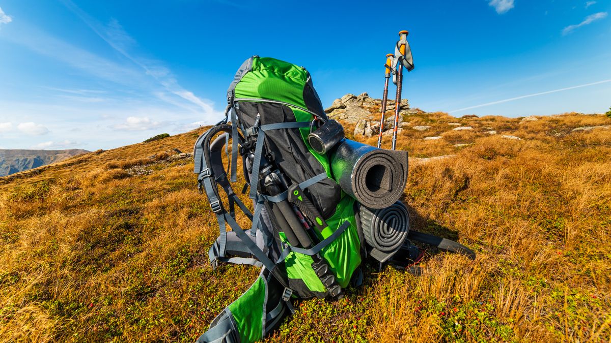 backpack and sleeping pad on a background of mountains