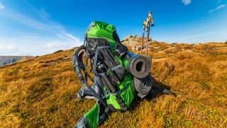 backpack and sleeping pad on a background of mountains