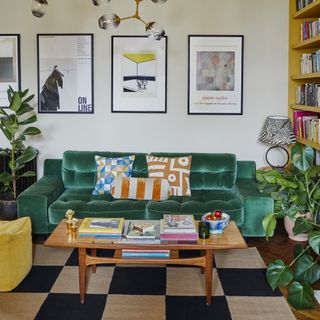 Living room with green velvet sofa, mid-century coffee table and gallery wall.