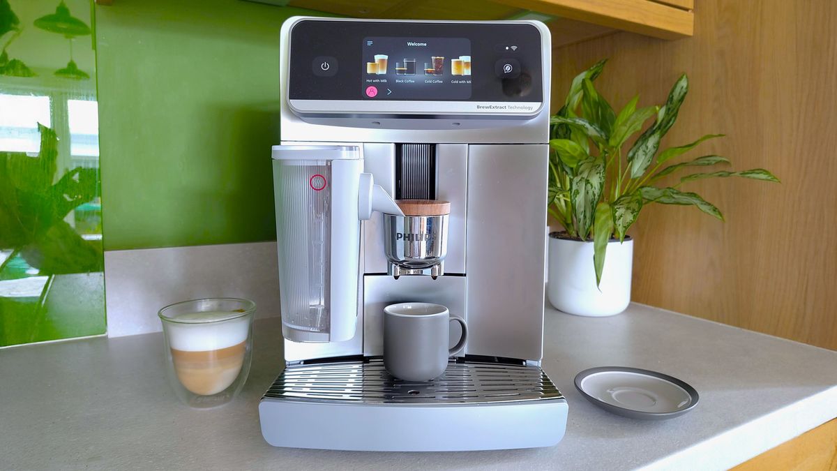 Philips Cafe Aromis Series 8000 coffee maker on kitchen counter with coffee and house plant