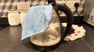 Empty kettle being wiped with mirofiber cloth 