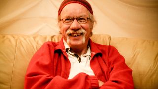 Ex-Soft Machine musician Hugh Hopper relaxing in 2008 wearing a red beanie hat and cardigan