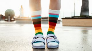 Person wearing rainbow socks with sandals