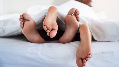 how to have good sex, couple&#039;s feet poking out from under sheets