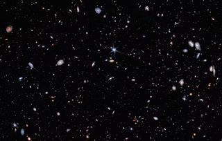 A deep field image showing hundreds of stars and galaxies