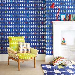 Colourful children's bedroom with robot design wallpaper and fabric armchair