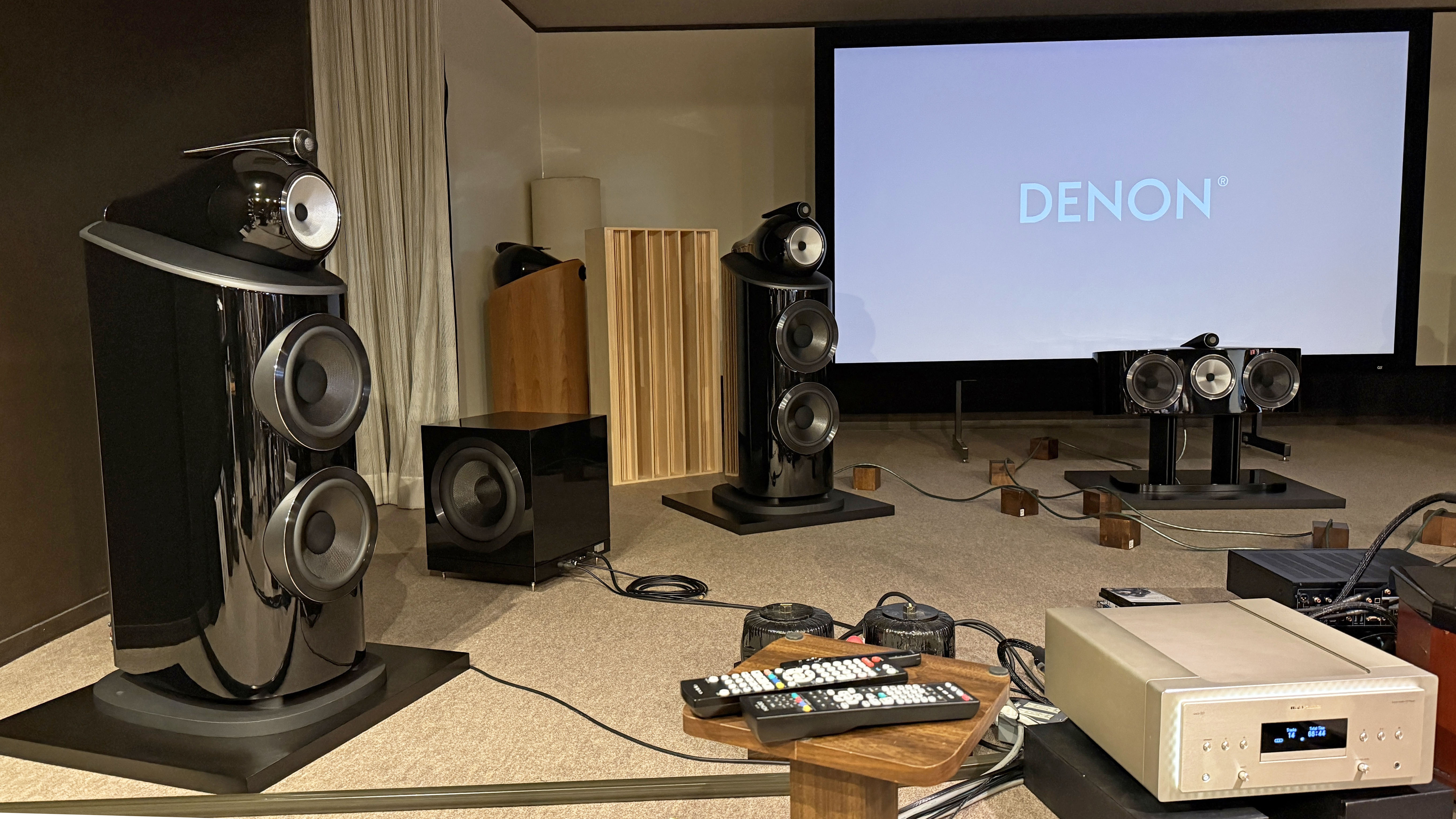 The interior of a home theater listening room with Bowers &amp; Wilkins 801 D4 speakers and a Marantz amp in front of a projector