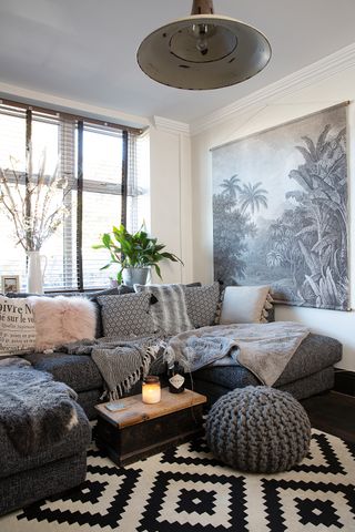 Living room with large corner sofa, coffee table and monochrome rug