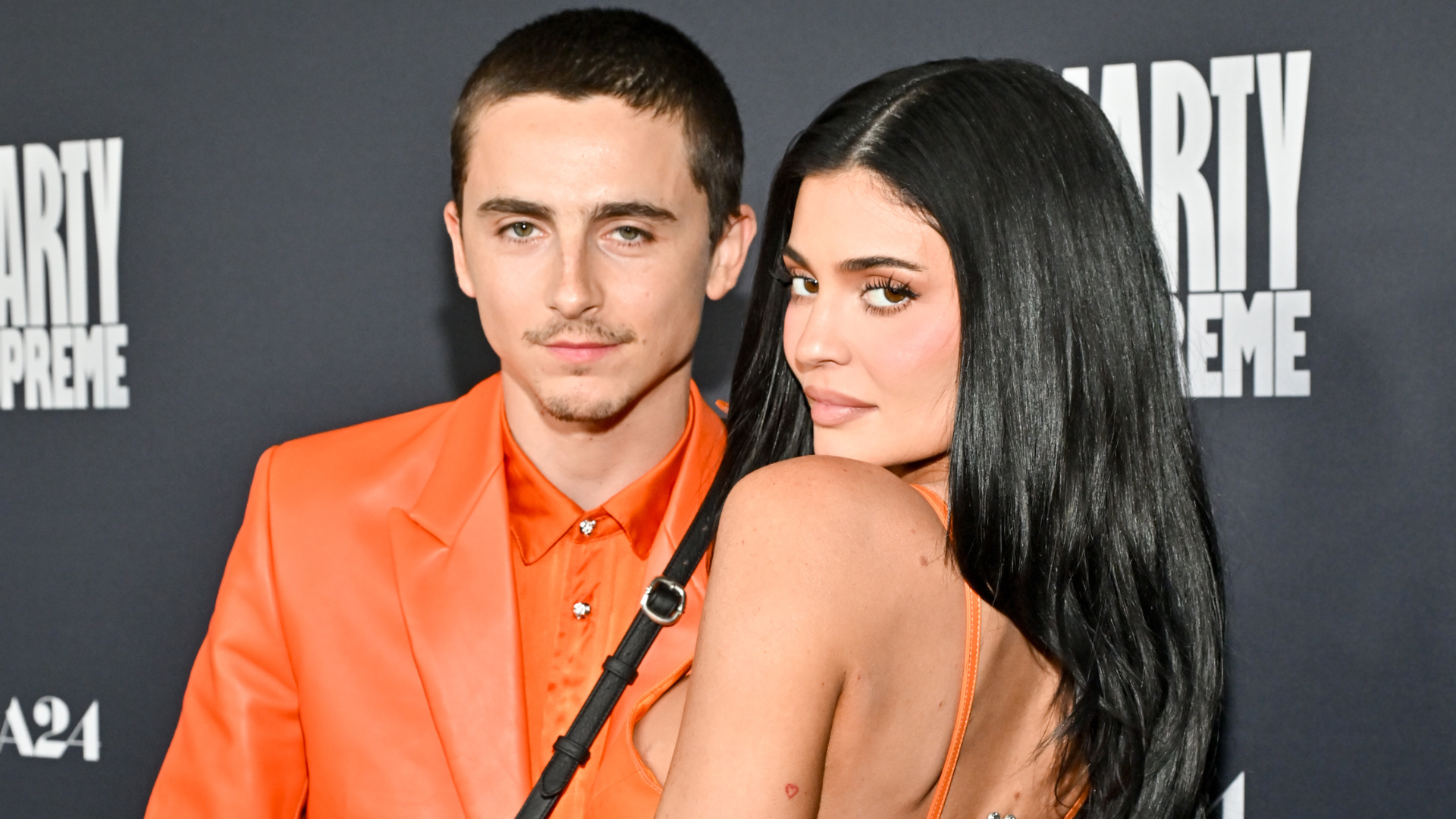 a man and a woman in orange outfits