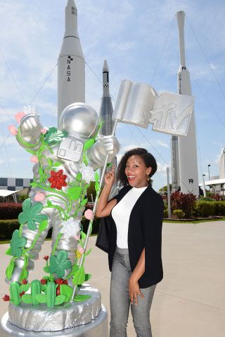 Moogega Cooper, NASA's lead planetary protection engineer for the Mars 2020 mission, poses with a life-size version of MTV's "Moon Person" at the Kennedy Space Center Visitor Complex in Florida.