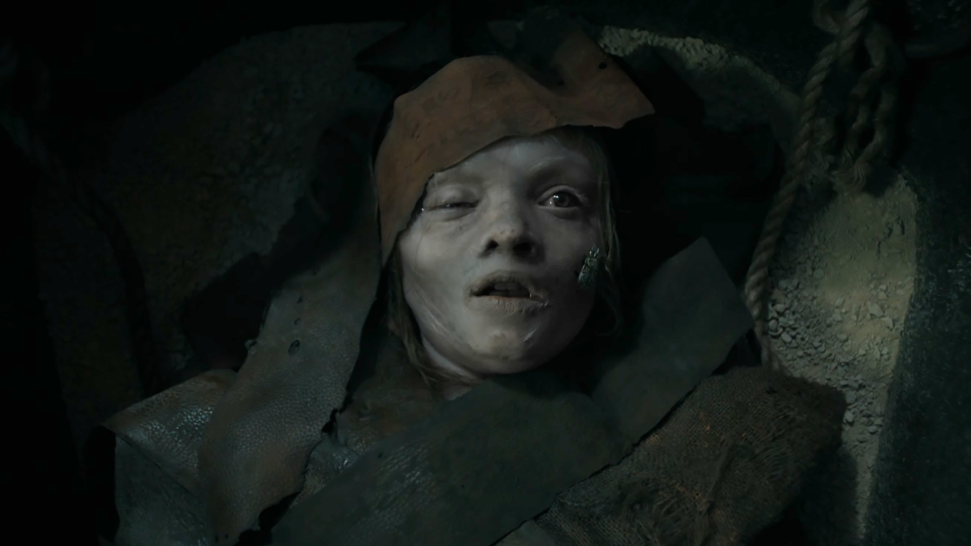 A young girl swaddled in rags awakening from death