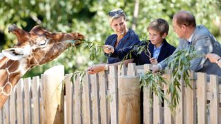 Duchess Sophie, James Viscount Severn, Prince Edward feeding a giraffe