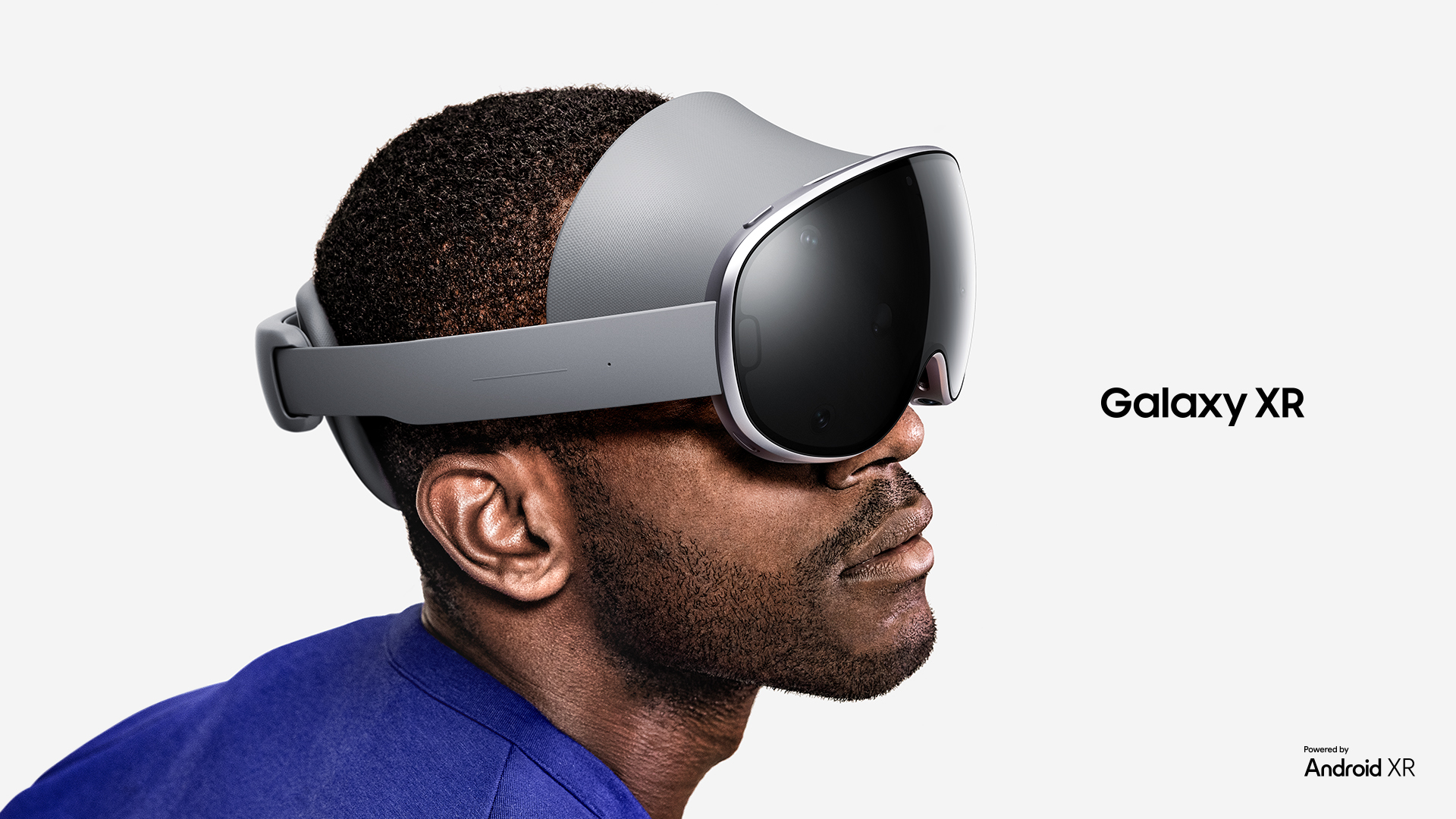 A side profile of a man wearing a grey mixed-reality headset with a glossy black visor against a plain white background, featuring the text "Galaxy XR" and "Powered by Android XR".