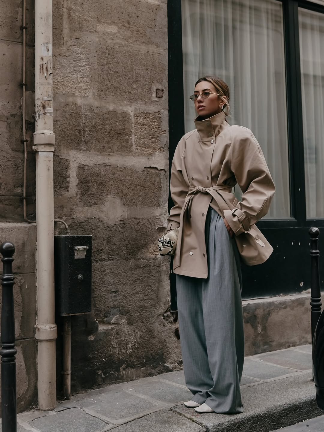 Hannah Lewis stylist wearing a funnel-neck jacket and grey trousers.