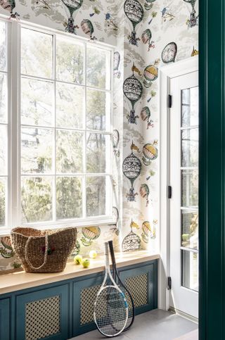 mudroom entryway with hot air balloon wallpaper and vented cabinets