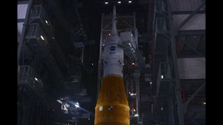 NASA's Space Launch System rocket with the Orion capsule atop ahead of a launch pad rollout.
