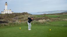 A golfer hitting an iron shot off the tee