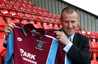 Steve Claridge holds up his shirt as he is unveiled as player-manager of Weymouth in 2003