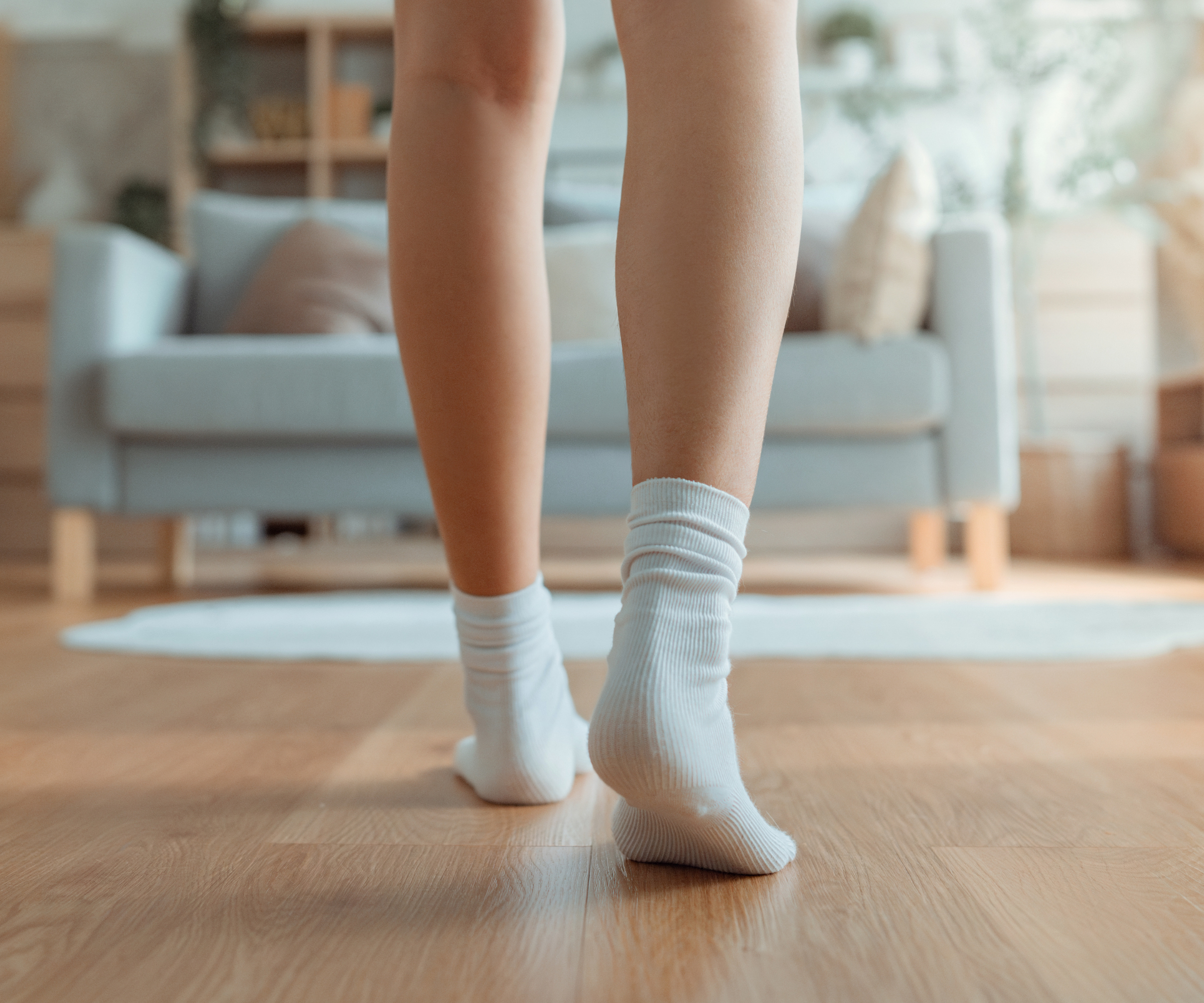 person walking on wooden floor with socks on